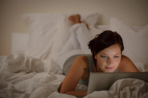 Slaapkamer avond - vrouw met laptop — Stockfoto
