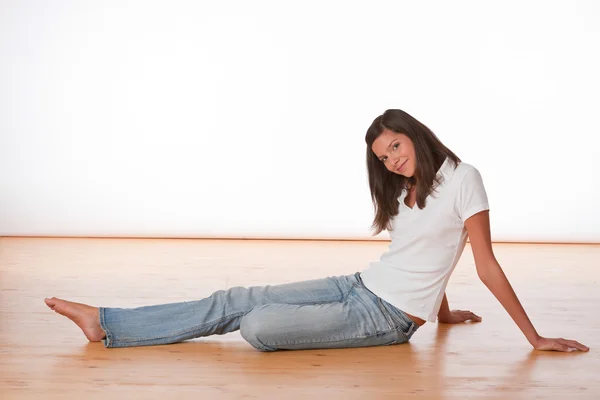Gelukkig tiener zittend op houten vloer — Stockfoto
