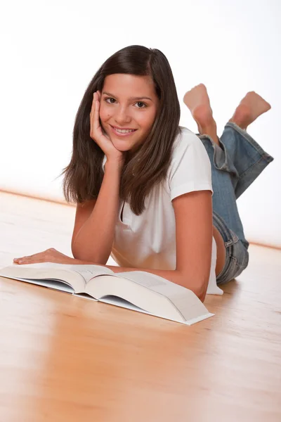 Šťastný teenager vleže s knihou — Stock fotografie