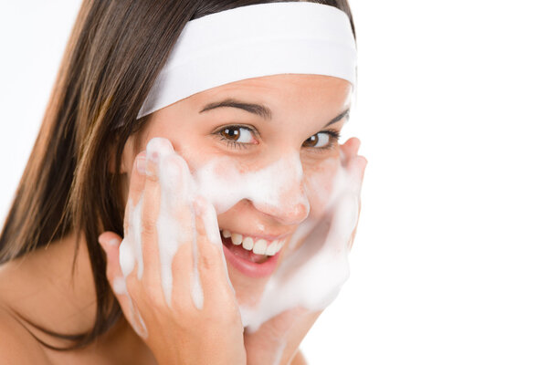 Teenager problem skin care - woman wash face with cleansing foam