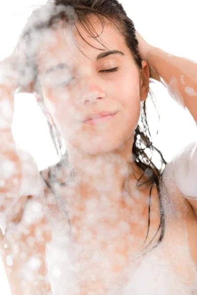 年轻女人享受淋浴在白色背景上 — 图库照片