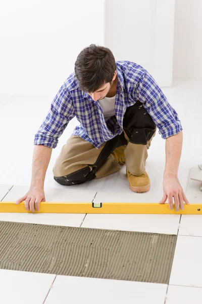 首页瓷砖改进 水平铺设瓷砖地板的打杂工 — 图库照片