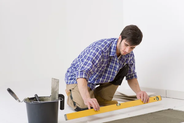 Mejora de azulejos para el hogar - manitas con nivel — Foto de Stock