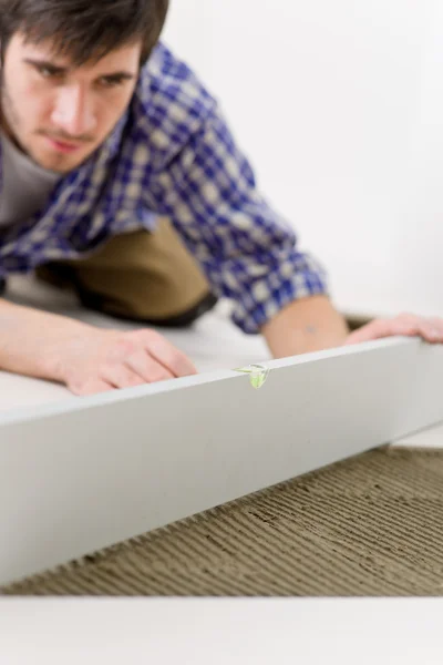 Home tile improvement - handyman with level — Stock Photo, Image