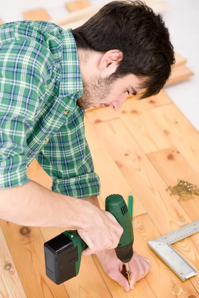 Home improvement - handyman installing wooden floor — Stock Photo, Image