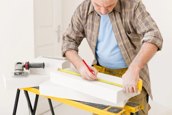 Hem förbättring - handyman mäta poröst tegel — Stockfoto