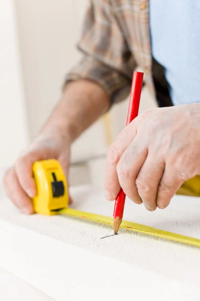 Улучшение дома - мастер измеряет пористый кирпич — стоковое фото