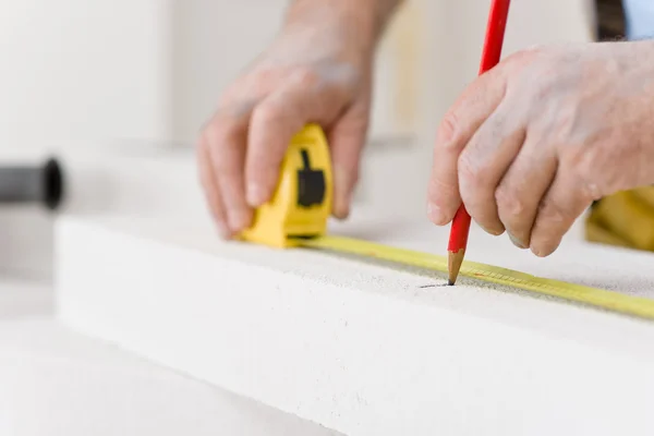 Melhoria da casa - handyman medida de tijolo poroso — Fotografia de Stock