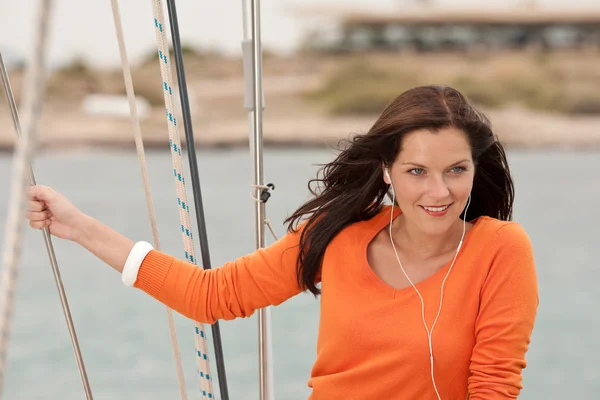 Attractive woman standing on sailing boat with headphones — Stock Photo, Image