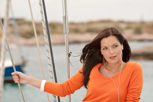 Aantrekkelijke vrouw permanent op zeilboot met koptelefoon — Stockfoto