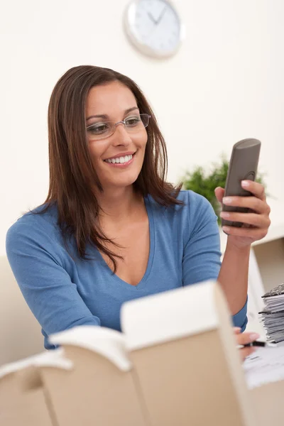 Mladá žena architekt pracující v kanceláři drží telefon — Stock fotografie