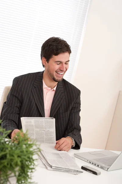 Successful modern businessman with laptop and newspaper — Stock Photo, Image