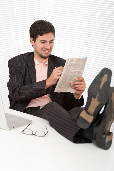 Empresário moderno bem sucedido com laptop e jornal — Fotografia de Stock