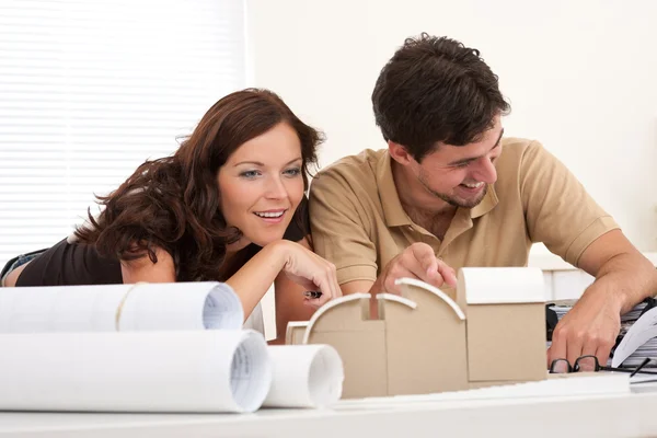 微笑着的男人和女人在办公室建筑模型 — 图库照片