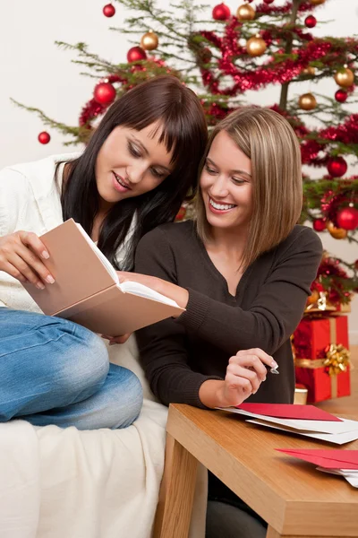 Duas Jovens Mulheres Escrevendo Cartões Natal Frente Árvore — Fotografia de Stock