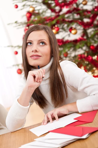 Jovem Mulher Pensando Escrever Cartão Natal Frente Árvore — Fotografia de Stock