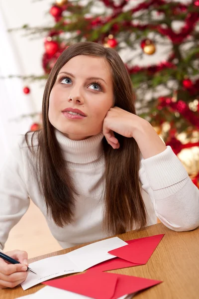 年轻女人写作圣诞贺卡 — Stockfoto