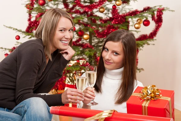 Dos jóvenes con champán y árbol de Navidad — Foto de Stock