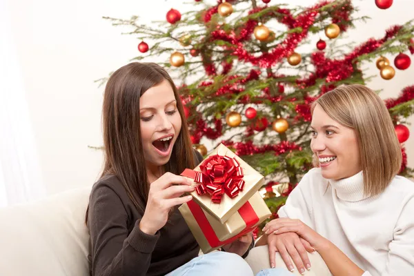 Junge Frau packt Weihnachtsgeschenk aus — Stockfoto