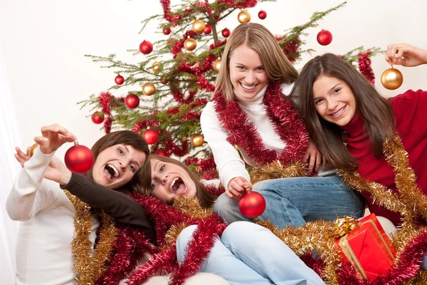 Quatro jovens mulheres se divertindo no Natal — Fotografia de Stock