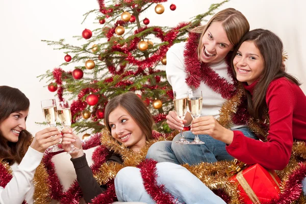 Τέσσερις γυναίκες χαμογελώντας με ποτήρι σαμπάνια για τα Χριστούγεννα — Φωτογραφία Αρχείου