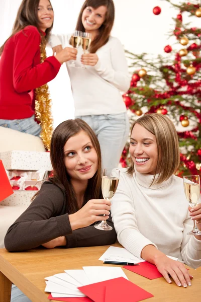 四个微笑妇女与玻璃的香槟在圣诞节 — 图库照片
