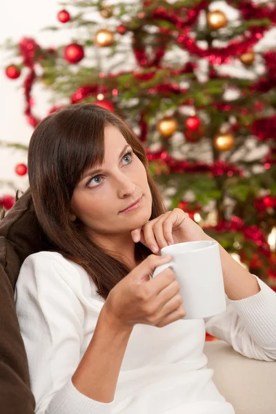 コーヒーのカップを保持しているクリスマス ツリーの前で魅力的なブルネット — ストック写真