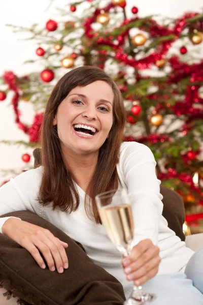 Brunt hår kvinna sitter med glas champagne på jul — Stockfoto