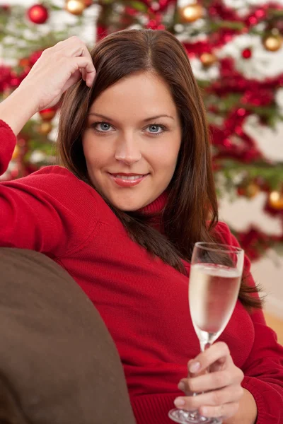シャンパン グラスでクリスマス ツリーの前に魅力的な茶色の髪の女性 — ストック写真