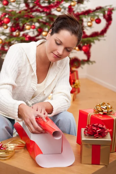 Молодая женщина упаковывает подарок на Рождество — стоковое фото