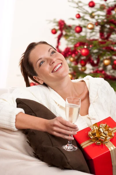 Mulher sorridente com presente de Natal e copo de champanhe — Fotografia de Stock