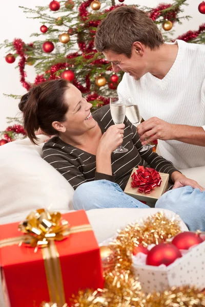 Jeune couple avec champagne devant l'arbre de Noël — Photo