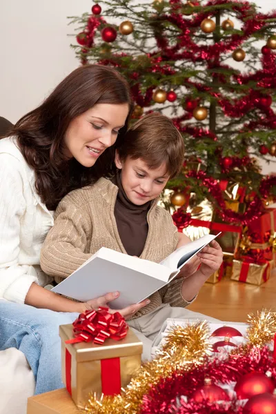 Νεαρή μητέρα με τον γιο, διαβάζοντας το βιβλίο για τα Χριστούγεννα — Φωτογραφία Αρχείου