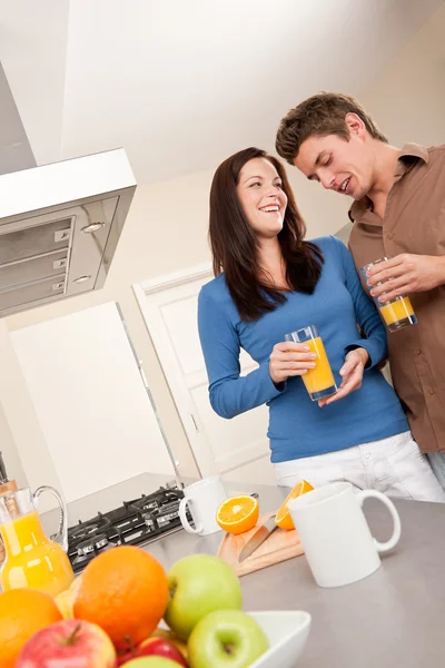 Mladý muž a žena pít pomerančový džus — Stock fotografie