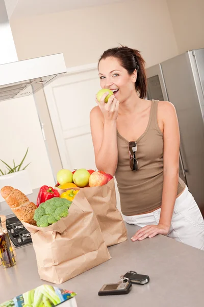 Junge Lächelnde Frau Mit Einkäufen Der Küche Beißt Apfel — Stockfoto