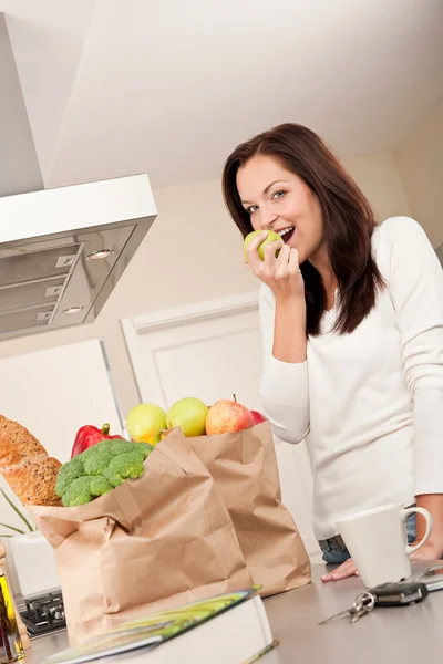 Mladá usměvavá žena s potravinami v kuchyni — Stock fotografie