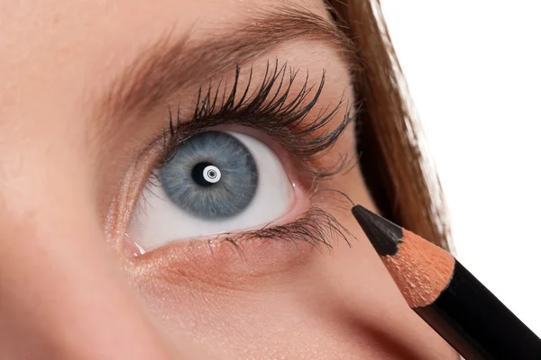 Primer plano del ojo azul, mujer aplicando lápiz negro —  Fotos de Stock