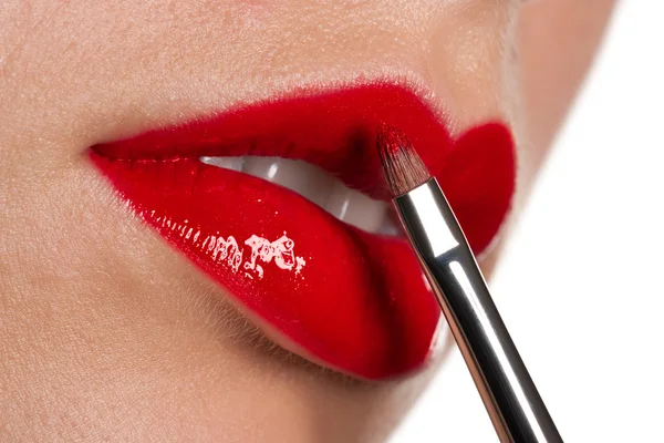 Frau trägt glänzend roten Lippenstift auf weißem Hintergrund auf — Stockfoto