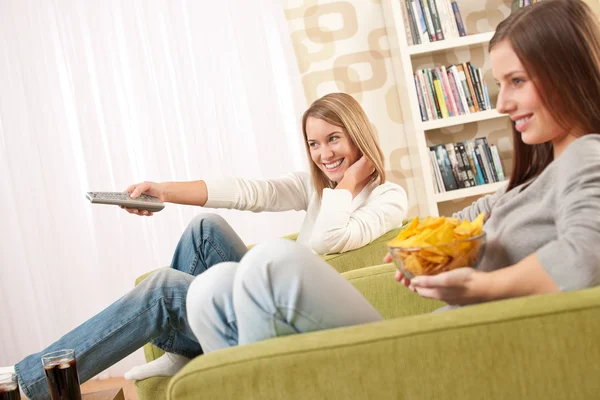 Estudantes Duas Adolescentes Assistindo Televisão Comendo Batatas Fritas Lounge Moderno — Fotografia de Stock