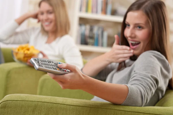 Studenten Twee Vrouwelijke Tiener Televisiekijken Moderne Woonkamer Glimlachend Richten Afstandsbediening — Stockfoto