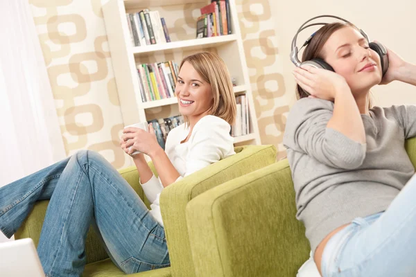 两个女性青少年在休息室喝咖啡 听听音乐放松 — 图库照片