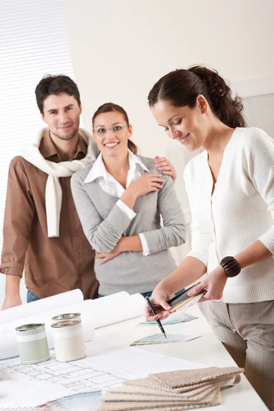 Interior designer femminile con due clienti in ufficio — Foto Stock