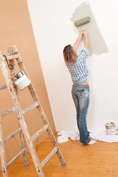 Amélioration de la maison : Femme gaie avec rouleau de peinture et échelle — Photo
