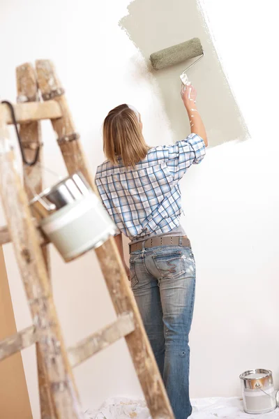 家里的改进 金发美女绘画墙体涂料滚子 — 图库照片