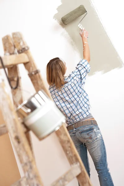 Miglioramento della casa: donna allegra con rullo di vernice e scala — Foto Stock