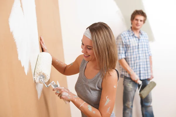 Renovering: ung man och kvinna måleri vägg — Stockfoto
