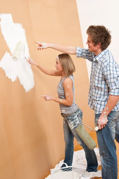 Home verbetering: jonge man en vrouw schilderij muur — Stockfoto