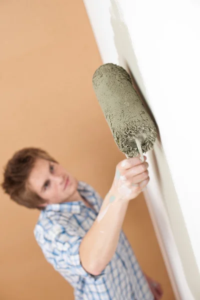家里的改进 油漆滚筒绘画墙的年轻人 — 图库照片