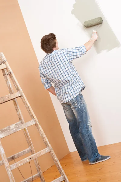 家里的改进 面漆辊涂和梯子的年轻人 — 图库照片