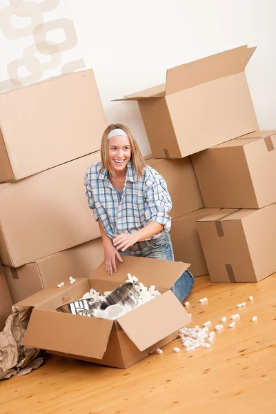 Переезд: счастливая женщина распаковывает коробку — стоковое фото